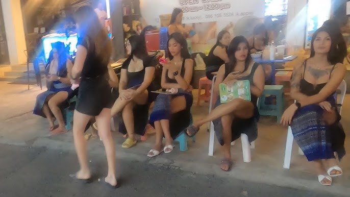 Sexy Thai masseuses in revealing outfits outside Bangkok massage parlor waiting for customers